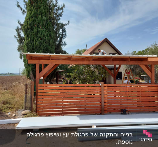מבנה עץ עם גג, אדם עובד על הגג, סולם בצד